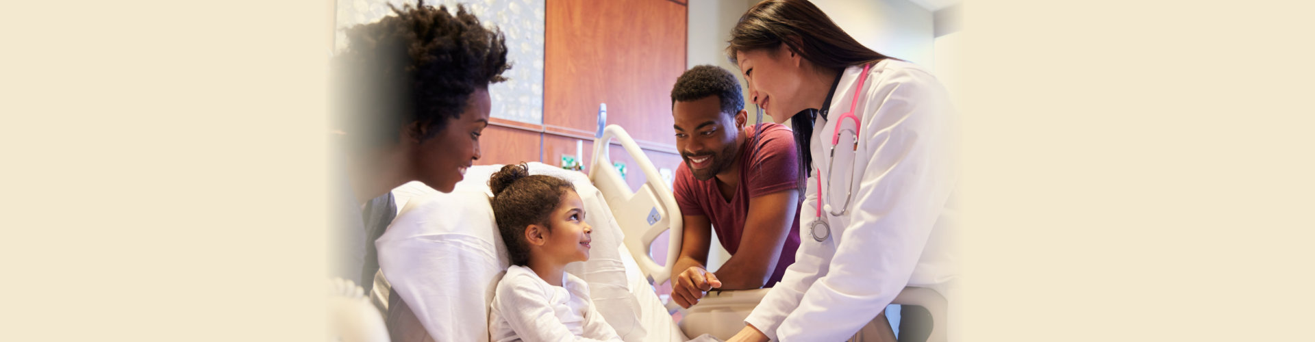 kid on hospital bed with parents on her side